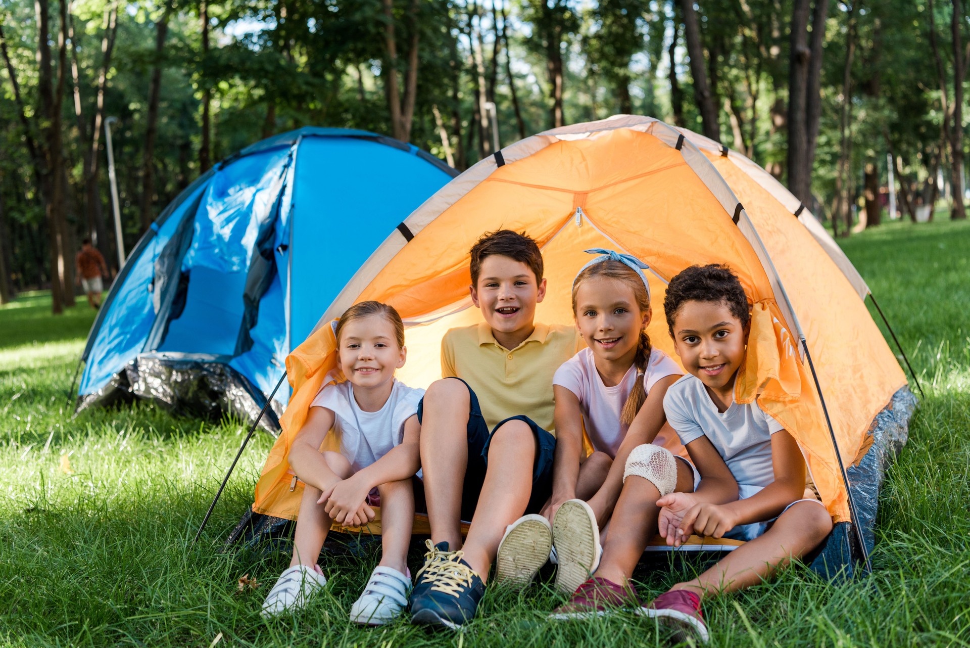 felice multiculturale bambini sorridenti mentre sono seduti in campo giallo